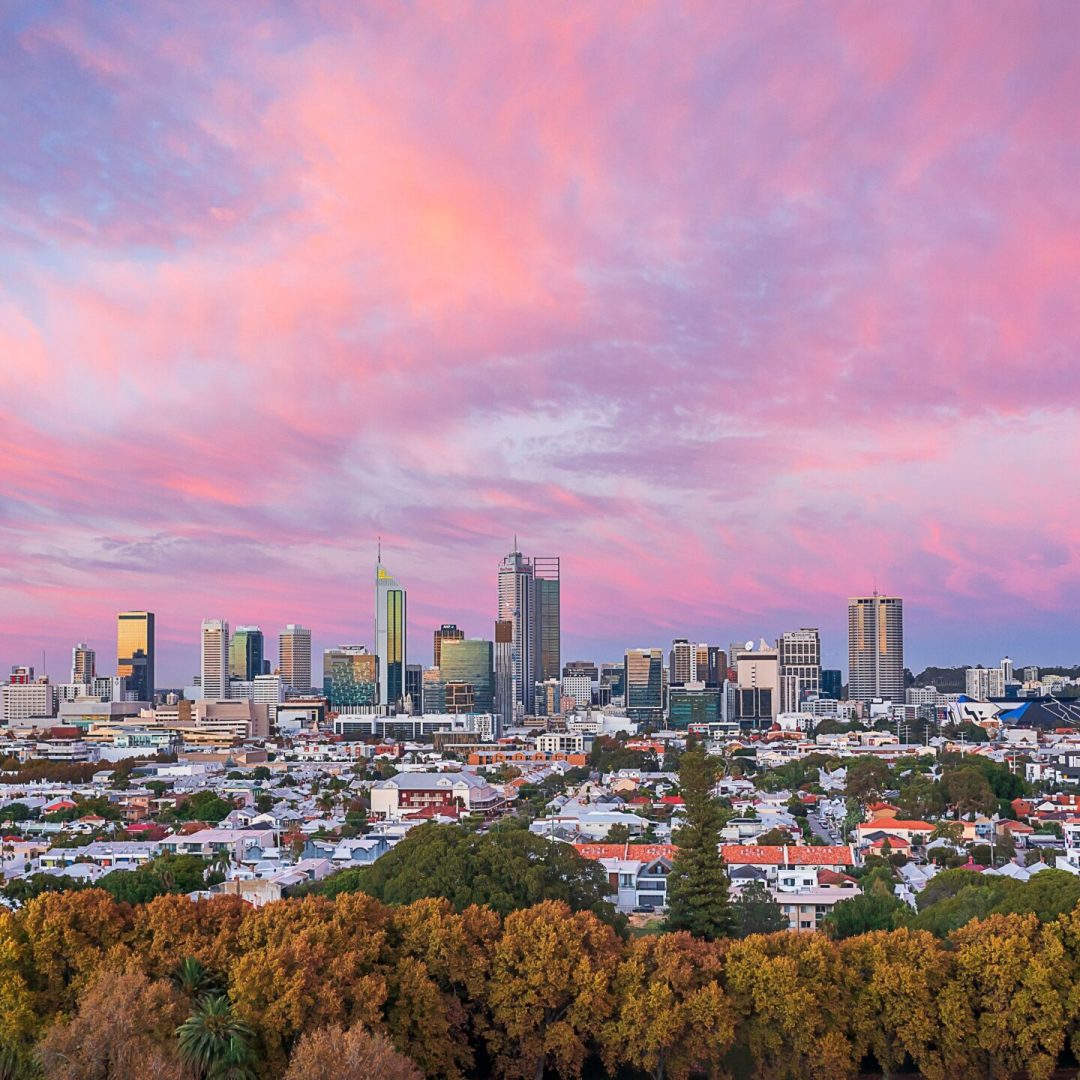An aerial view of the skyline of Brisbane, Australia with a colorful and vibrant sky as the background